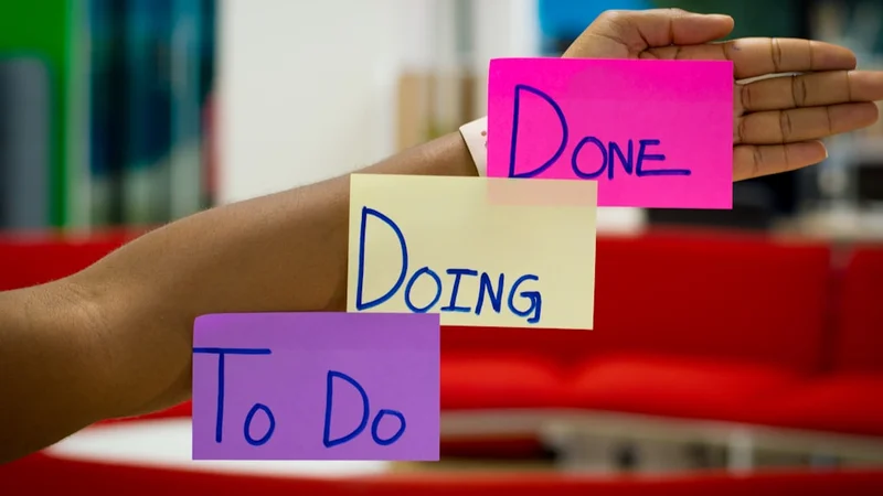 minimalistischer Schreibtisch mit einer physischen mechanischen Eieruhr, einem geschlossenen Notizbuch und einem einzigen Stift — die bewusste Einfachheit einer ablenkungsfreien Arbeitsumgebung