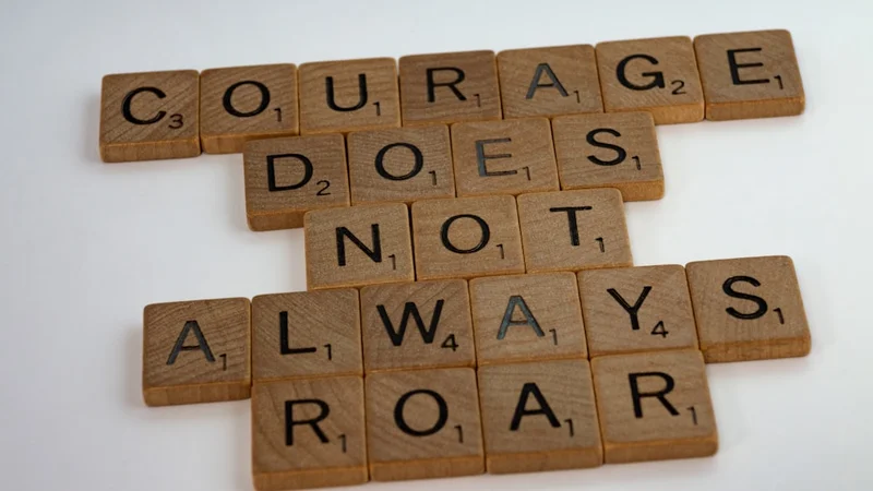 Eine einsame Gestalt an einem Scheideweg in einer weiten offenen Landschaft in der Morgendämmerung, warmes Licht bricht am Horizont, das die tägliche Wahl zwischen Bequemlichkeit und Wachstum evoziert