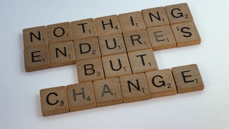 Eine Person sitzt ruhig an einem Schreibtisch mit Kaffee, blickt auf ein aufgeschlagenes Notizbuch — nachdenklich, nicht beunruhigt