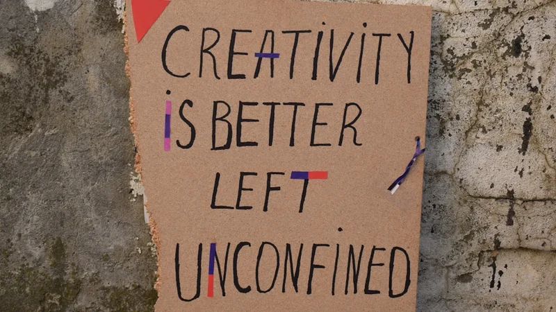 Nahaufnahme einer Person, die in einem strukturierten Tagesplaner auf einem Holzschreibtisch schreibt, neben der eine analoge Stoppuhr liegt