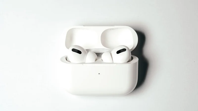 Apple AirPods Max USB-C in Midnight finish resting on desk next to iPhone, clean Apple aesthetic