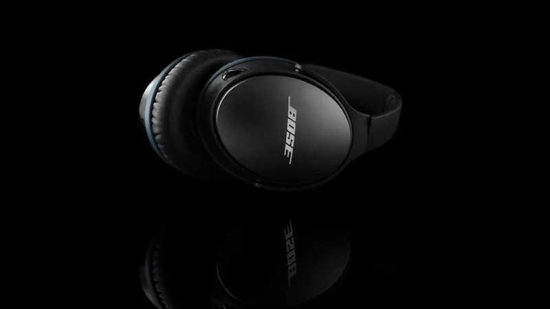 Bose QuietComfort 45 headphones on clean white desk surface, minimalist editorial style, white background