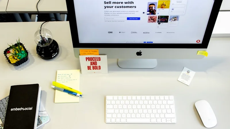 flat lay of an open A5 dotted notebook, a capped pen, and several index cards spread on a wooden desk from above in warm natural light