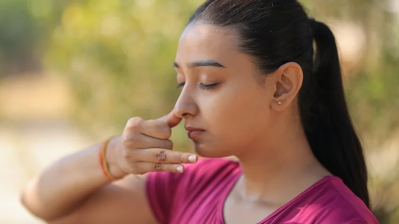 Close-up of a person breathing calmly through their nose, natural light, peaceful expression, sitting near a window