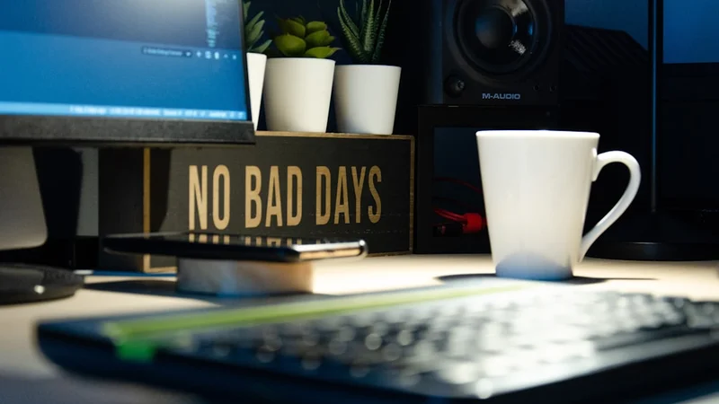 Flat-lay minimalista de un espacio de trabajo ordenado con un pequeño bloc de notas, un bolígrafo y una taza de café