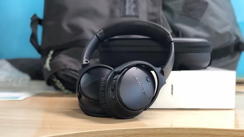 Auriculares Bose QuietComfort Ultra sobre escritorio de madera con iluminación cálida