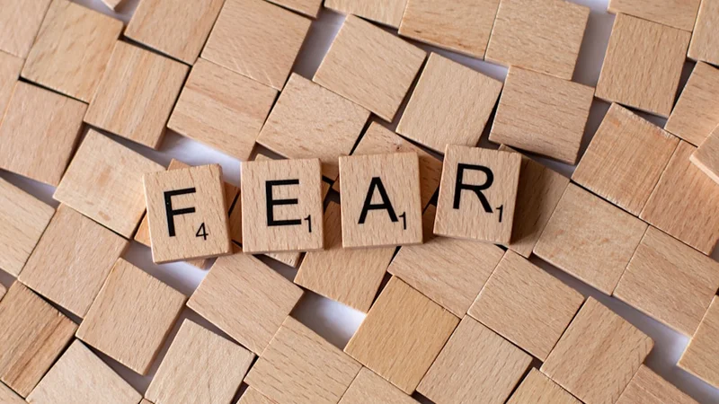 Una persona caminando con confianza a través de una puerta abierta hacia una luz brillante, simbolizando superar el miedo para entrar a un nuevo capítulo