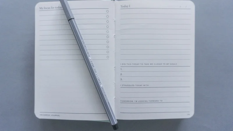 diario abierto con notas manuscritas y una taza caliente sobre una mesa de madera con luz matinal, que representa la reflexión intencional sobre los patrones de conexión social y la pertenencia como práctica diaria