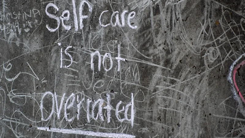 Personne assise à un bureau épuré, regard perdu fixé sur un ordinateur portable, lumière naturelle traversant la fenêtre, représentant la perte de motivation au travail