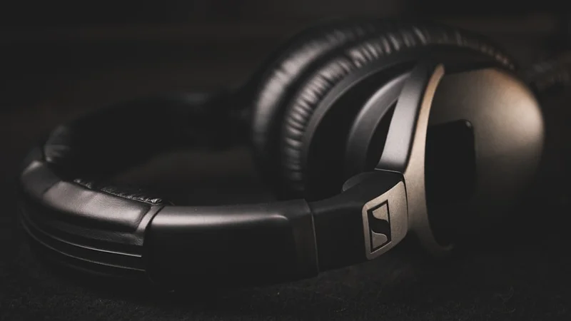 Casque Sennheiser Momentum 4 Wireless à côté d'un équipement hi-fi avec lumière ambiante chaleureuse