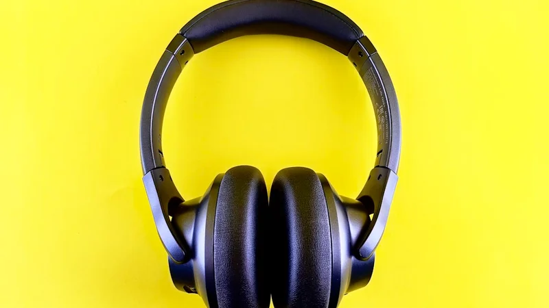 Casque Anker Soundcore Space Q45 sur bureau en bois à côté d'un ordinateur portable ouvert