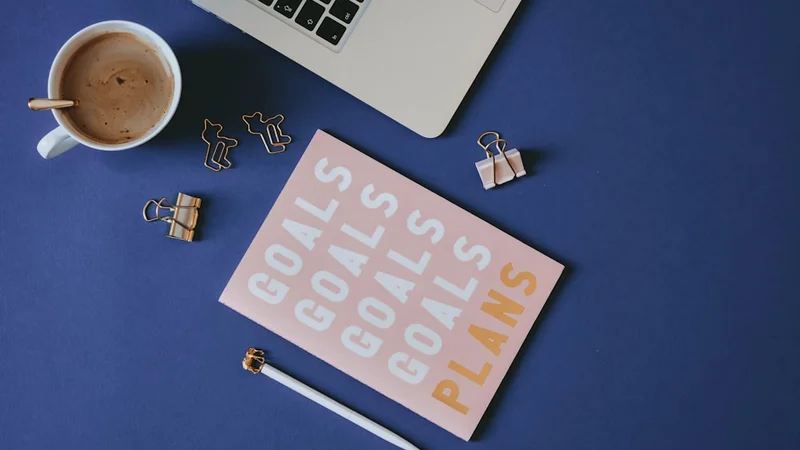 Un journal ouvert avec des notes manuscrites à côté d'une tasse de café sur une table en bois, lumière matinale