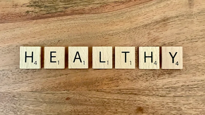 Una persona anziana che fa escursione su un sentiero soleggiato attraverso colline verdi, aspetto energico e sano, movimento naturale a metà passo