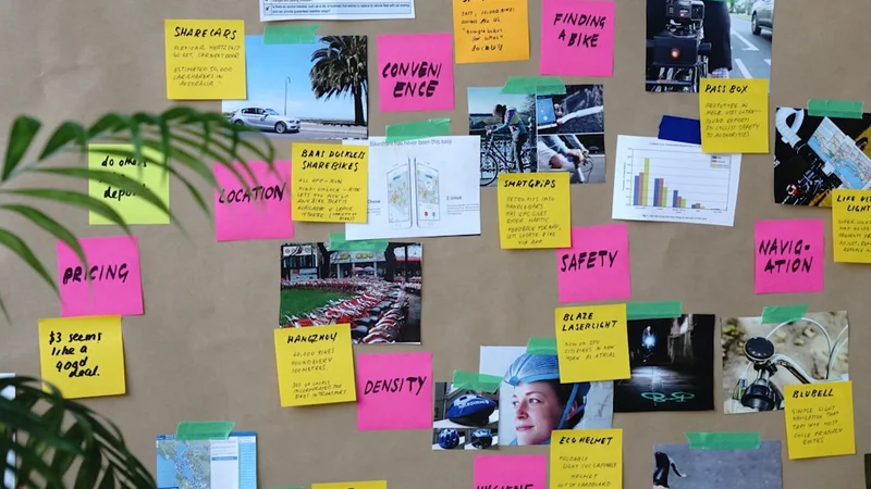 Primo piano di mani che appuntano un'immagine specifica di un obiettivo su una vision board con traguardi scritti visibili