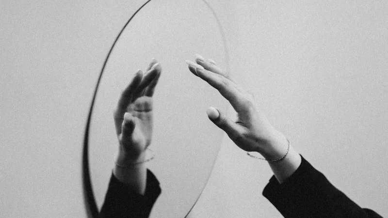 Uma pessoa escrevendo com foco em um caderno numa mesa iluminada de manhã cedo, com uma xícara de café ao lado