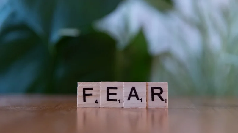 Um caderno aberto em três páginas mostrando a estrutura do fear-setting com anotações à mão, colunas para Definir, Prevenir, Reparar e Custo da Inação