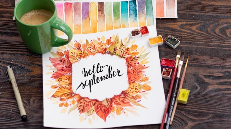 Pessoa abrindo um caderno em branco sobre uma mesa de madeira com luz suave de manhã, ao lado de uma xícara de café e flores de primavera