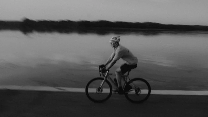 Uma pessoa escrevendo em um diário em uma mesa, luz da manhã entrando pela janela, expressão tranquila e focada