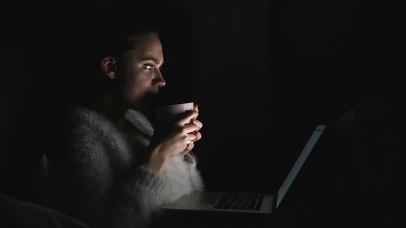pessoa deitada acordada no escuro olhando para o teto, luz ambiente suave, cinematográfico e silencioso